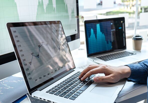 Laptop and monitor showing marketing analytics charts