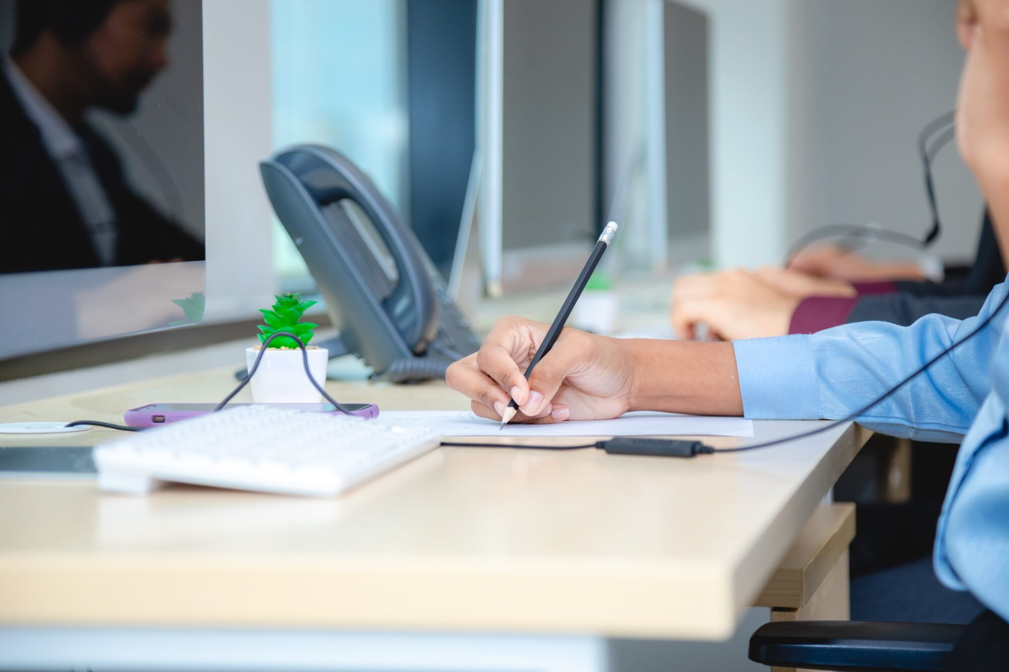 Intake specialist taking notes during a phone call